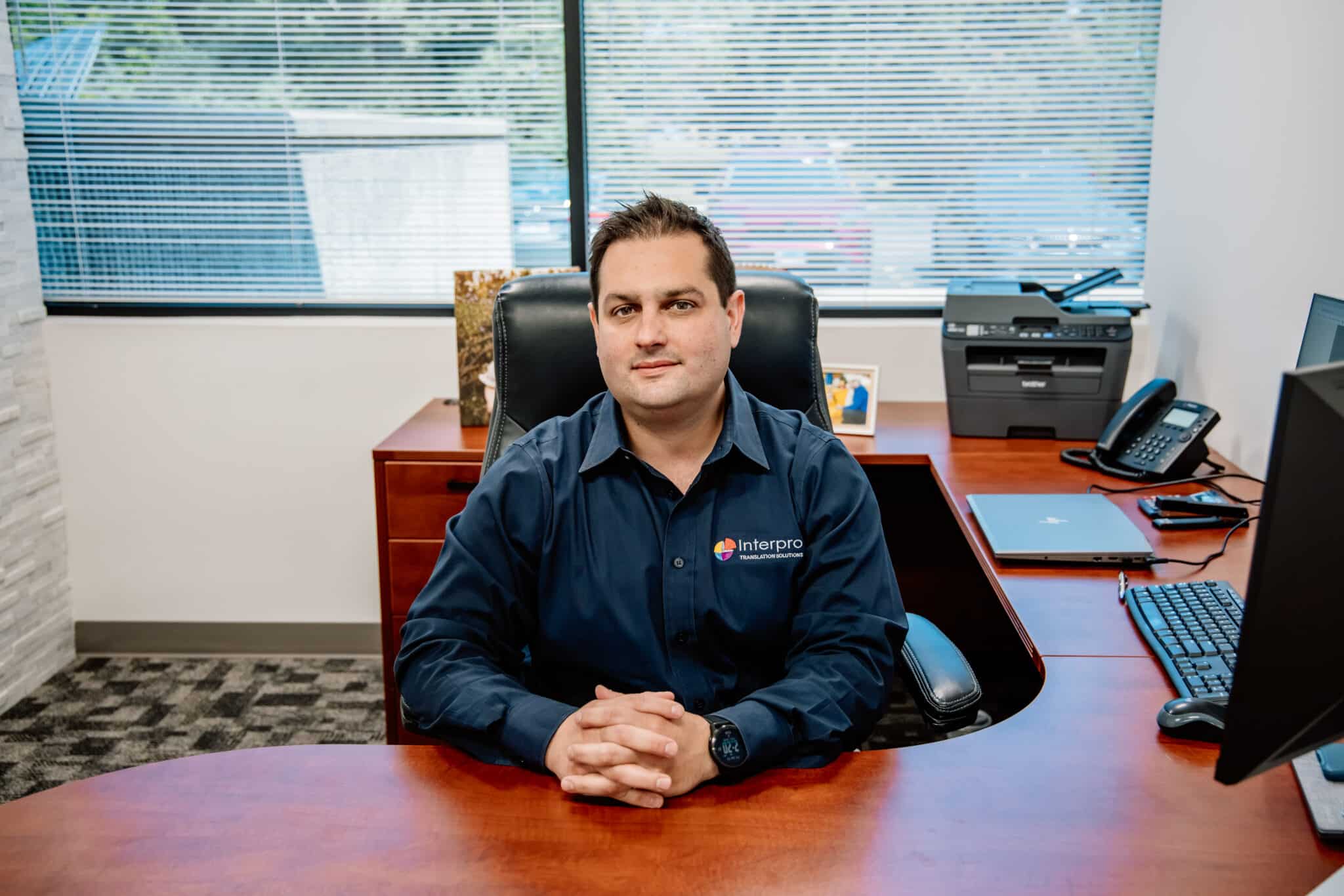 Nick Strozza, CEO of Interpro Translation Solutions, seated at his office desk