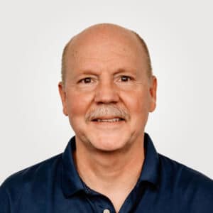 Dean Haman, in sales at Interpro, smiling in a professional headshot wearing a black polo shirt.