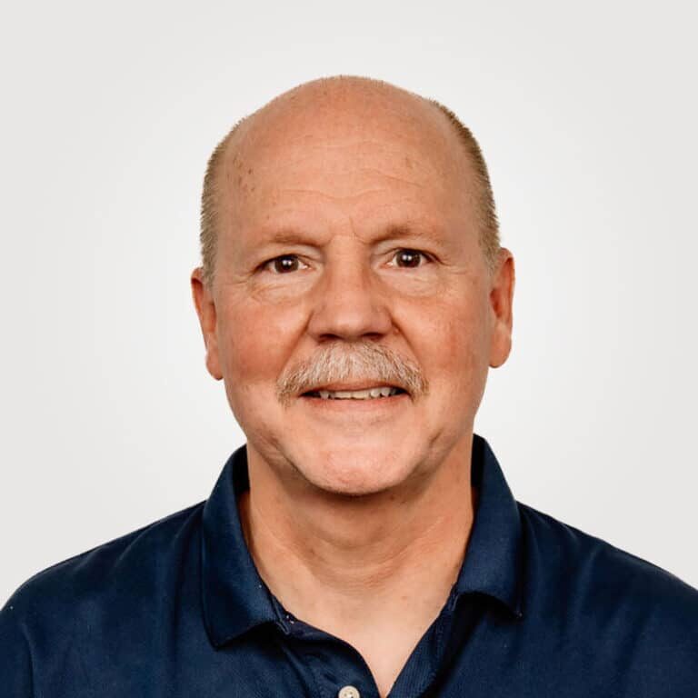 Dean Haman, in sales at Interpro, smiling in a professional headshot wearing a black polo shirt.