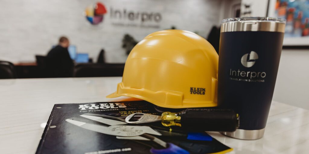 Klein Tools hard hat, tools, and Interpro-branded tumbler displayed together