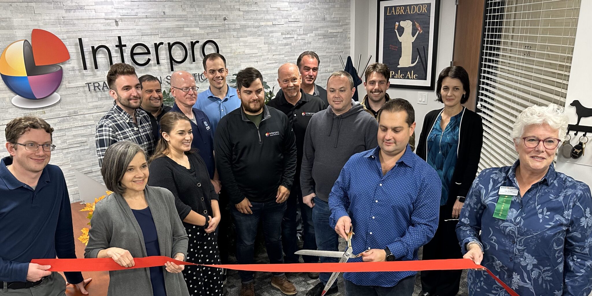 Team members of Interpro gathered in the lobby of the headquarters to participate in ribbon cutting.