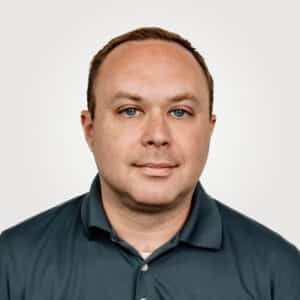 Justin Carrell, in engineering at Interpro, smiling in a professional headshot wearing a black polo shirt.