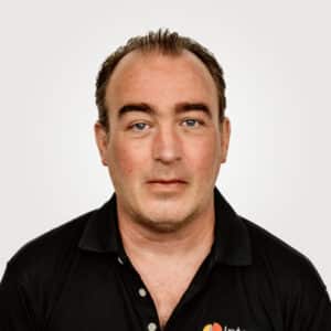 Larry Pilotto, in multilingual desktop publishing at Interpro, smiling in a professional headshot wearing a black polo shirt.