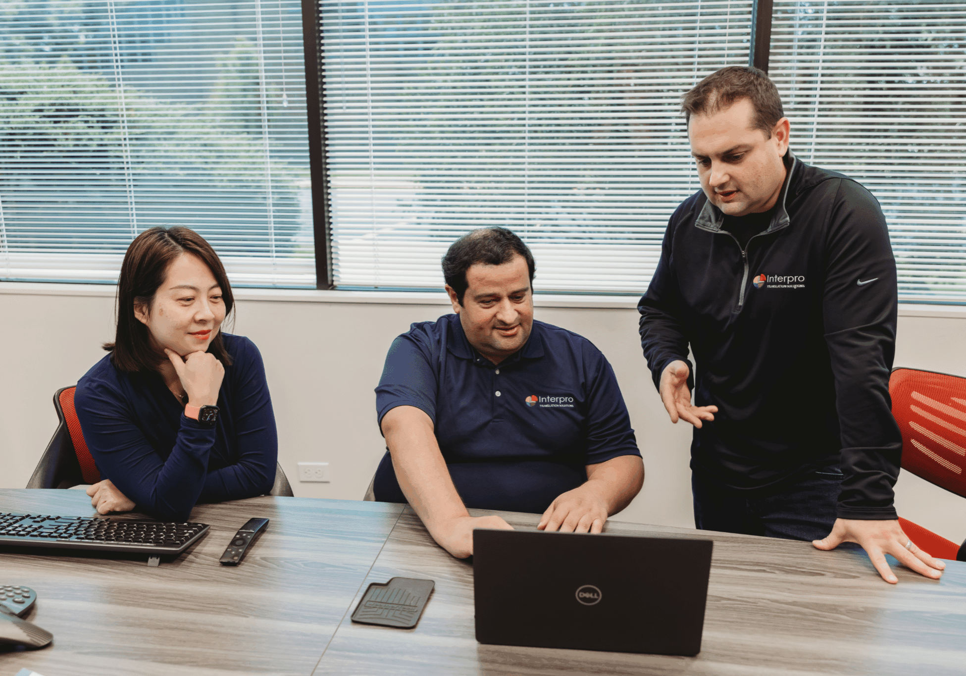 Interpro Translation Solutions team collaborating on localization strategy around a laptop in the office