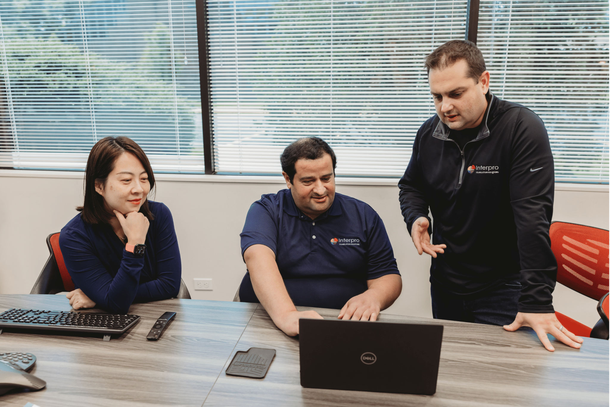 Interpro Translation Solutions team collaborating on localization strategy around a laptop in the office